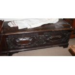 A LARGE 18TH CENTURY CARVED OAK COFFER Having two cast iron carry handles, the front panel carved