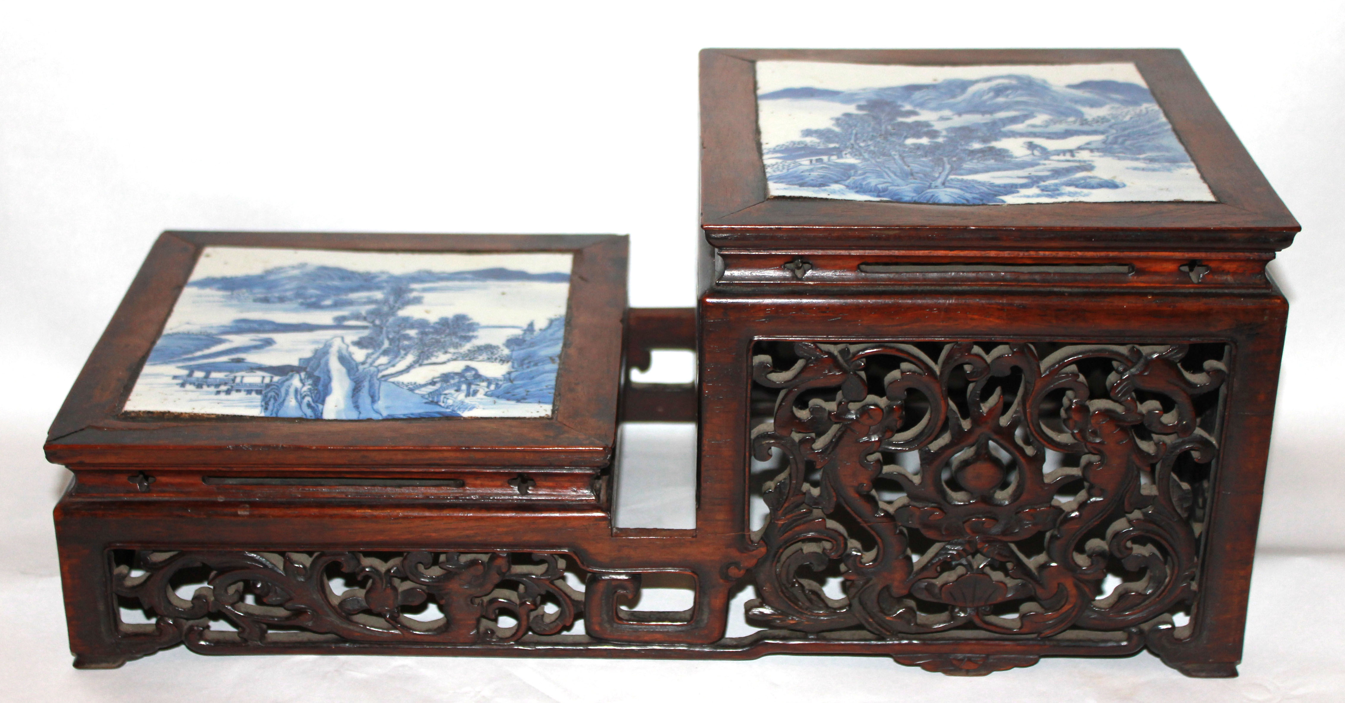 A 19TH CENTURY TWO TIER WOODEN STAND Inset with two blue and white panels of landscapes, the pierced