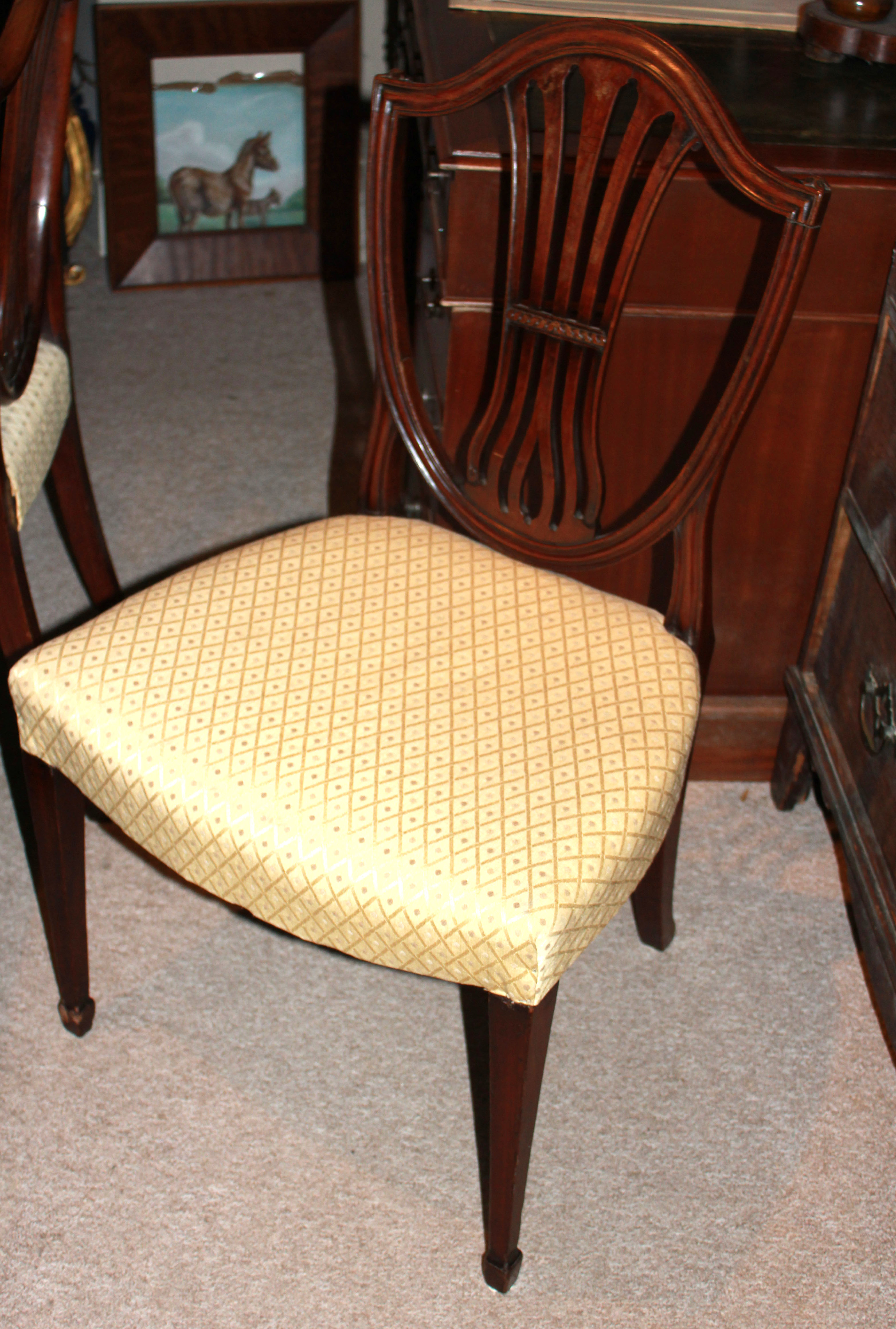 A SET OF SIX GEORGE III PERIOD MAHOGANY DINING CHAIRS With shield backs and overstuffed seats,