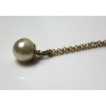 A VINTAGE 9CT GOLD AND PEARL PENDANT NECKLACE The single pearl suspended from a fine link gold