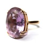 A VINTAGE 9CT GOLD AND AMETHYST RING Having a large oval cut amethyst set in a geometric style mount