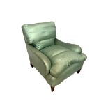 A HOWARD STYLE UPHOLSTERED EASY ARMCHAIR Raised on square tapered legs and castors. (approx 80cm x