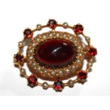 A VINTAGE 9CT GOLD, GARNET AND SEED PEARL BROOCH The single cabochon cut garnet surrounded with seed