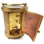 A 20TH CENTURY GILT BRASS CYLINDRICAL CARRIAGE CLOCK Having a rectangular white dial with black
