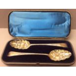 A PAIR OF GEORGIAN SILVER GILT BERRY SPOONS Bright cut engraving to handle, scalloped shaped bowl