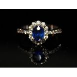 AN 18CT WHITE GOLD, SAPPHIRE AND DIAMOND RING Having a single oval cut sapphire surrounded by a