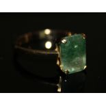 AN 18CT GOLD AND EMERALD RING Having a single baguette cut two tone emerald stone, set in a plain