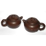 TWO CHINESE YIXING WARE TERRACOTTA POTTERY MINIATURE SPHERICAL TEAPOTS With applied decoration of