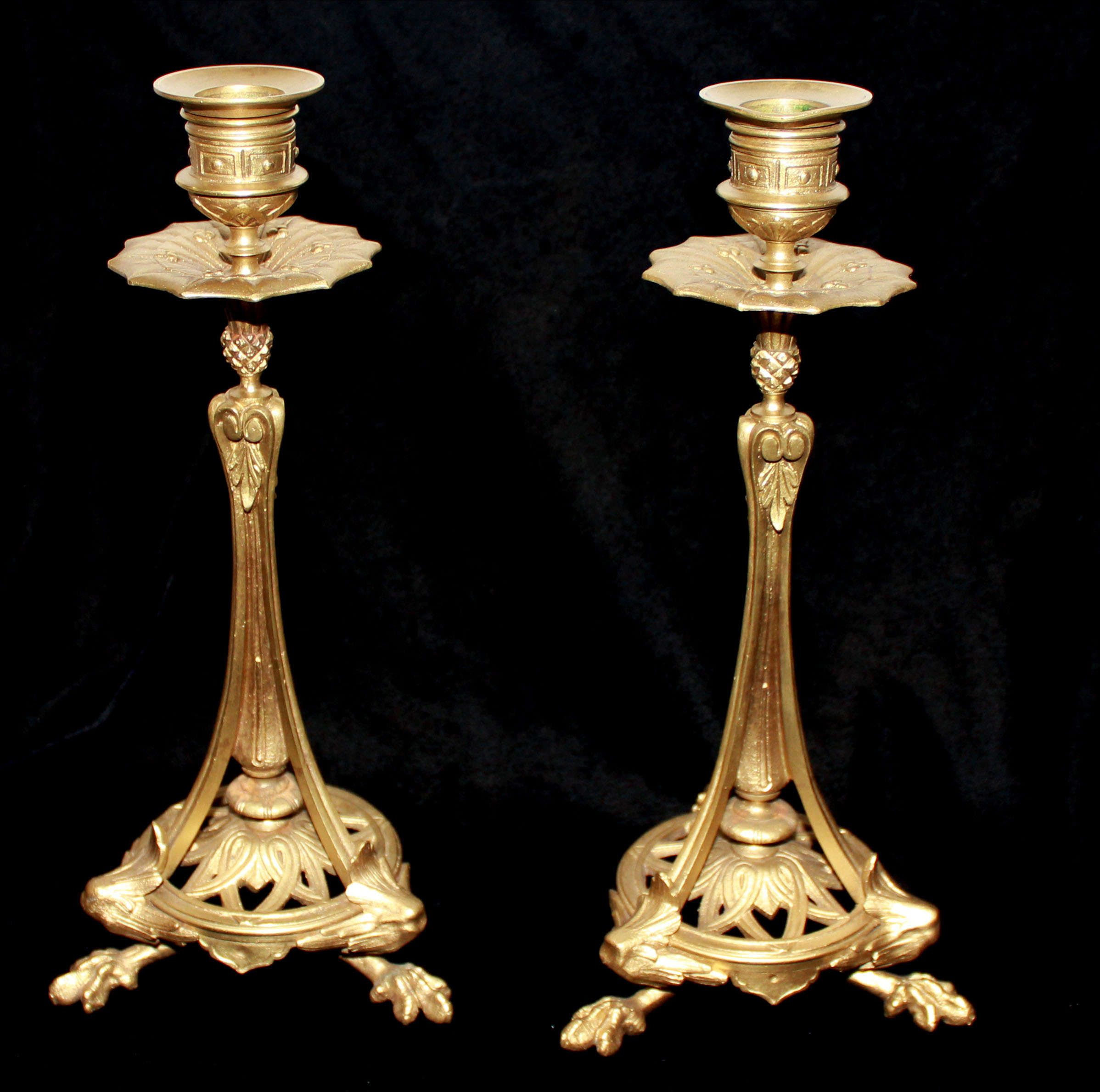 A PAIR OF ANTIQUE FRENCH GILT METAL CANDLESTICKS Having a floral form drip pan, the central column