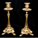 A PAIR OF ANTIQUE FRENCH GILT METAL CANDLESTICKS Having a floral form drip pan, the central column