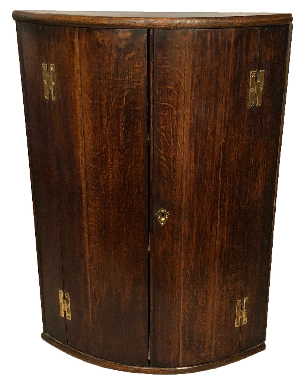 A GEORGIAN OAK HANGING CORNER CABINET With brass fittings and shelved interior. (h 84.5 x d 60cm)