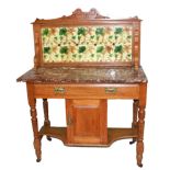AN EDWARDIAN WALNUT WASHSTAND The tiled back over a marble top, with drawer and cupboard door,