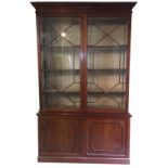 A 19TH CENTURY MAHOGANY BOOKCASE With dentil cornice and two astragal glazed doors above