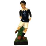 A MID 20TH CENTURY PAINTED PLASTER STATUE Depicted as a young football player in a blue jersey,