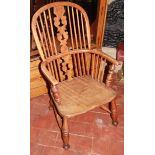 A 19TH CENTURY COUNTRY ELM STICK BACK ARMCHAIR Raised on turned legs joined by 'H' stretcher.