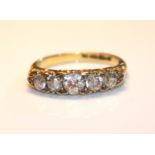 AN EARLY 20TH CENTURY 18CT GOLD AND DIAMOND FIVE STONE RING The graduating stones held in a