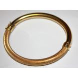 A VINTAGE 18CT GOLD BANGLE Having engine turned engraved decoration to top, with plain design to