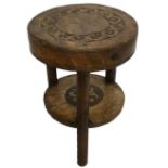 AN 18TH CENTURY WALNUT TRIPOD STOOL The circular top having a band of carved decoration. (approx