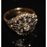 AN 18CT GOLD AND DIAMOND DAISY CLUSTER RING The single round cut diamond surrounded by a circle of