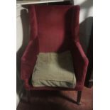 A GEORGIAN WING ARMCHAIR With square mahogany taping legs, on brass castors.