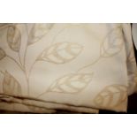 A PAIR OF CREAM SILK AND COTTON CURTAINS Decorated with beige stylized leaves.