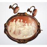 A VICTORIAN YELLOW METAL OVAL SHELL CAMEO BROOCH Finely carved with a classical interior scene,