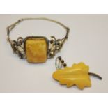 A CONTINENTAL SILVER AND YELLOW AMBER BROOCH Carved in a leaf design and set on a wirework frame,