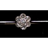 A WHITE METAL AND DIAMOND BAR BROOCH Having seven round cut diamonds set in stylized daisy form.