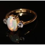 A VINTAGE 18C GOLD, OPAL AND DIAMOND RING The single cabochon cut opal flanked by a pair of