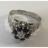 A 9CT WHITE GOLD, DIAMOND AND TOPAZ CLUSTER RING Having an arrangement of seven diamonds and six