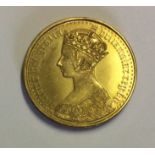 A RARE VICTORIAN 9CT GOLD 'GOTHIC HEAD' COIN Having the modern shield design to reverse, undated.