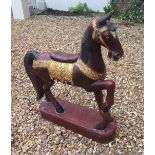 A 20TH CENTURY CARVED AND PAINTED HORSE STATUE With gilt decoration and scrolling motifs, raised