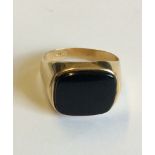 A 14CT GOLD AND BLACK ONYX GENT'S SIGNET RING Having an oval cut stone set in a plain gold shank,