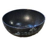 A LARGE PAPIER MACHÉ BOWL Bearing transfer printed blue willow pattern design on a black ground. (
