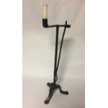 AN ANTIQUE WROUGHT IRON RUSH LIGHT With rush clasp and holder, raised on a square section support