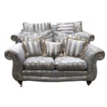 A CONTEMPORARY THREE SEAT SETTEE Upholstered in a pale blue floral fabric with loose cushions,