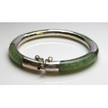 A VINTAGE SILVER AND JADE CIRCULAR BANGLE Set with a pierced silver mount and clasp.