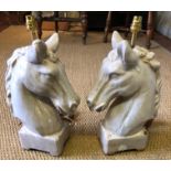 A PAIR OF HEAVY STONEWARE GLAZED TABLE LAMPS In the form of horses heads. (48cm)