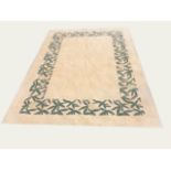 A CONTEMPORARY WOOLLEN RUG the cream ground contained in a green woven floral border 335 x 230 cm