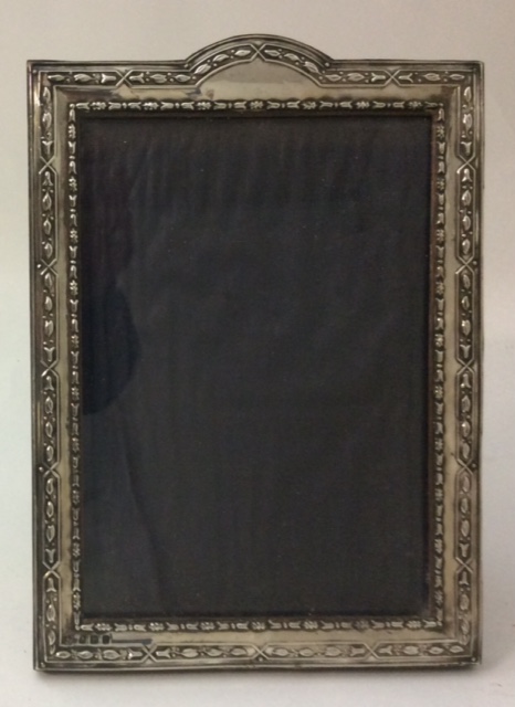 AN EARLY 20TH CENTURY SILVER PHOTO FRAME Embossed with a geometric floral style border and easel