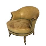 A VICTORIAN BEIGE LEATHER AND STUD UPHOLSTERED TUB ARMCHAIR Raised on gilt cabriole legs on brass