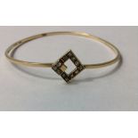 A VINTAGE 9CT GOLD AND DIAMOND BANGLE The single row of diamonds in a geometric design. (approx