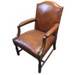 A 19TH CENTURY STYLE MAHOGANY OPEN ARMCHAIR With tan leather upholstery and shaped arms, raised on