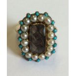 AN EARLY 20TH CENTURY 14CT GOLD, TURQUOISE AMD SEED PEARL MOURNING RING Having an oval panel