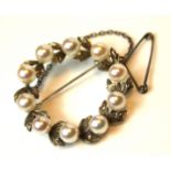 A VINTAGE WHITE METAL AND PEARL BROOCH Laurel wreath design interspersed with leaves. (approx