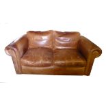 AN EARLY 20TH CENTURY DESIGN TAN LEATHER UPHOLSTERED TWO SEATER SETTEE With loose cushions. (176cm x