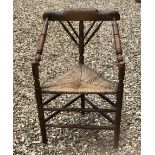 A VICTORIAN OAK THRONE CHAIR With turned spindles and rush seat.