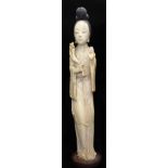 A 19TH CENTURY JAPANESE IVORY OKIMONO Carved in the image of a geisha, raised on an oval base. (h