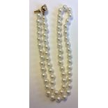 A 9CT GOLD AND PEARL NECKLACE Having a single strand of uniform pearls, leading to a 9ct gold