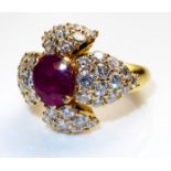 A FRENCH 18CT GOLD, RUBY AND DIAMOND RING Having a single oval cut ruby held within a leaf design,